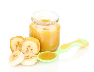 Jar of baby puree with banana and spoon isolated on white