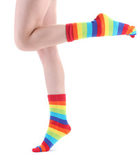 female legs in colorful striped socks isolated on white