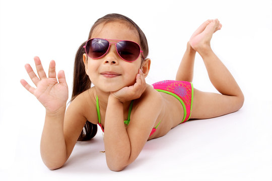 enfant avec maillot de bain et lunette de soleil allongée