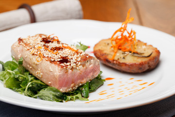 Fried tuna steak and potatoes on the plate