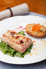 Fried tuna steak and potatoes on the plate