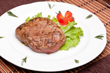 Grilled steak on a white plate