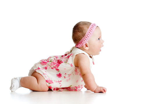 side view of pretty baby girl crawling on floor