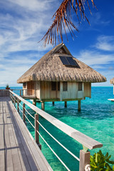 The wooden bridge to a hut over water at the ocean