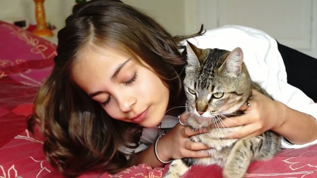 pr&eacute;ado avec son chat sur son lit