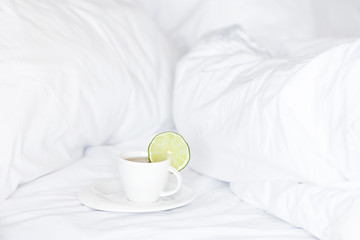 bed with a pillow and a cup of tea
