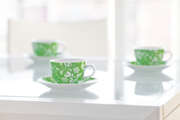 three cups of tea on a glass table