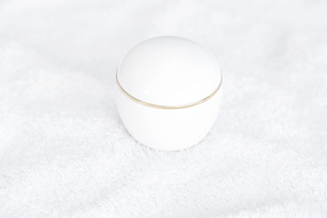 cosmetic containers lying on white towel