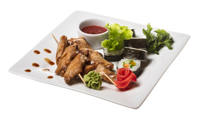 Buffalo chicken wings on plate with sushi