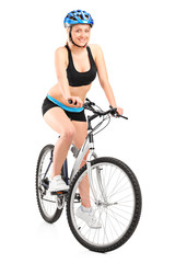 Fototapeta premium Portrait of a smiling female biker with helmet sitting on a bike