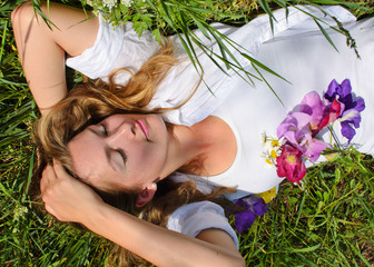 Naklejka premium Young, beautiful woman sleeping in the meadow