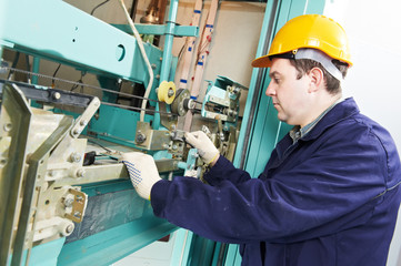 machinist with spanner adjusting lift mechanism