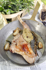 rabbit leg with herbs in a brassr pan