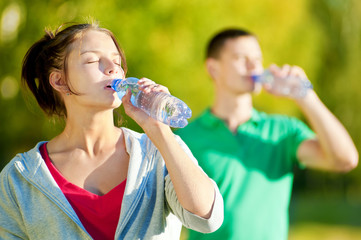 Man and woman drinking from bottle