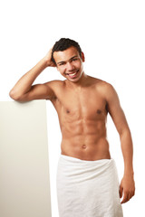 A nude young man covering himself with a towel