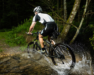 Mountainbiker durchquert Bachbett