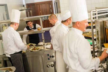 Group of cooks in professional kitchen