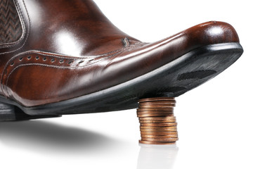Shiny businessman shoe step on the stack of coins. Isolated.