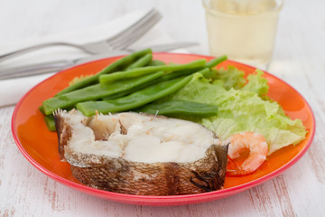 boiled fish with beans and lettuce on the plate