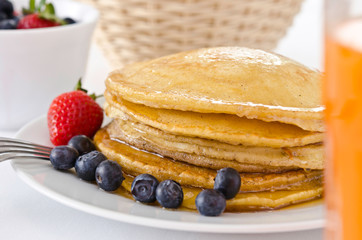Pile of golden pancakes topped with honey