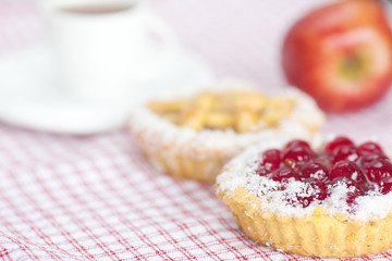 beautiful cake with berries,apple and tea on plaid fabric