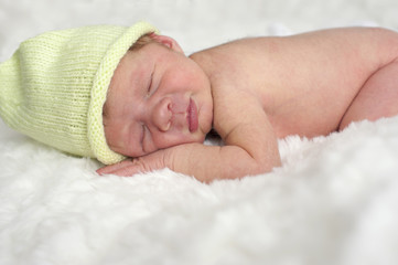 sleeping newborn baby with green hat