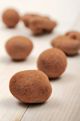 chocolates covered cocoa, on wooden table