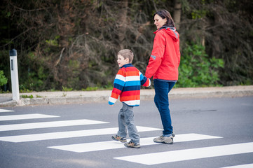 Mutter und Sohn überqueren Strasse
