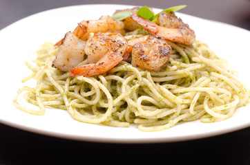 plate of spaghetti broccoli pesto and prawn ready for serving