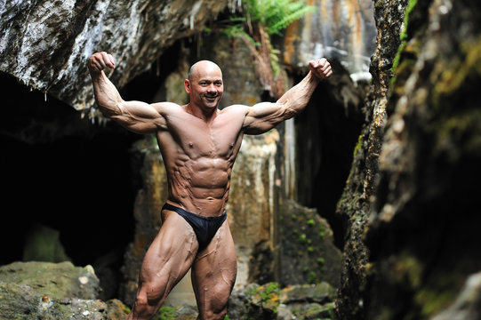 Bodybuilder posing in a cave