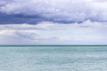 Fototapeta na wymiar Piękne lazurowe morze i frajer w pochmurne niebo