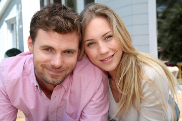 Portrait of smiling couple standing in front of house