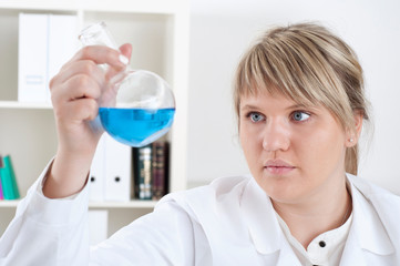 female chemist mixing liquids in test tubes
