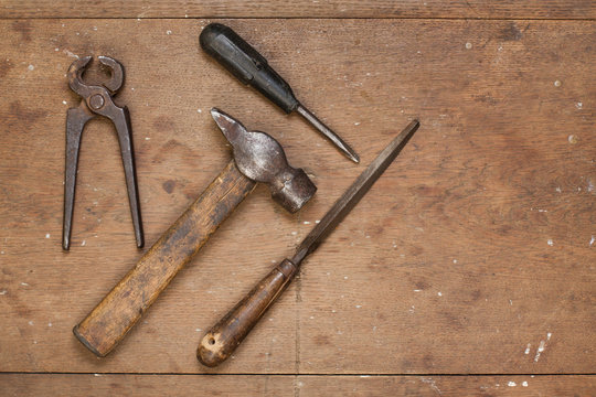 Old hammer, pincers, rasp on grunge wood background