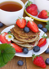 A stack of pancakes with a creamy fresh summer berries