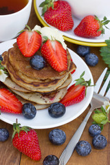 A stack of creamy pancakes with a fresh summer berries
