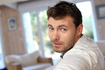 Portrait of young smiling man relaxing in sofa