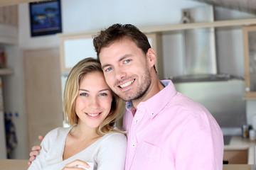 Portrait of in love couple standing in home kitchen