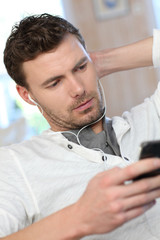 Portrait of young man listening to music with smartphone