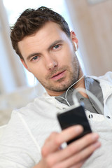 Portrait of young man listening to music with smartphone