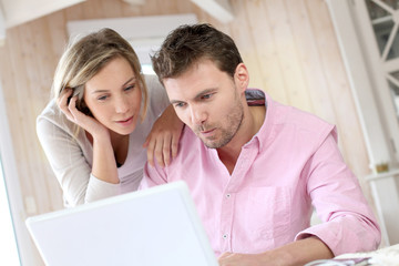 Couple at home using laptop computer