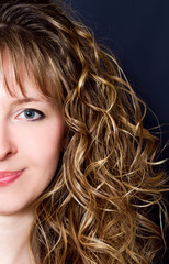 young woman with long curly hair half face