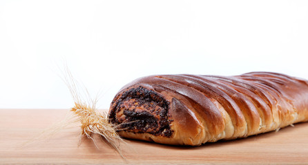 Strudel with poppy seeds on a wooden table.