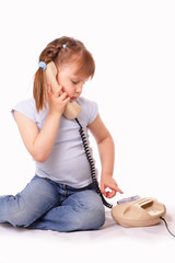 Pretty little girl dials the number on the old phone