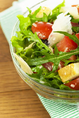 salad from tomatoes, rucola, grated parmesan cheese  on wooden