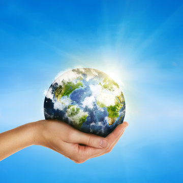 hand holding globe over blue sky - elements of this image furnis