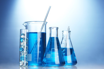 Test-tubes with blue liquid on blue background