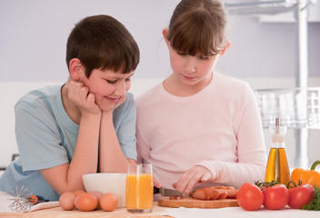 Boy and Girl eating breakfast cereal at home