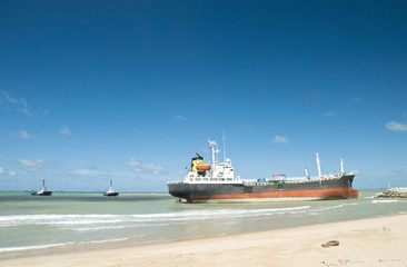 Naklejka premium Cargo ship run aground on rocky shore
