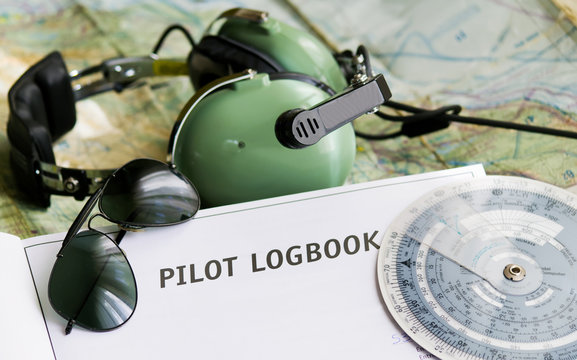 sunglasses, pilot logbook and aviation tools